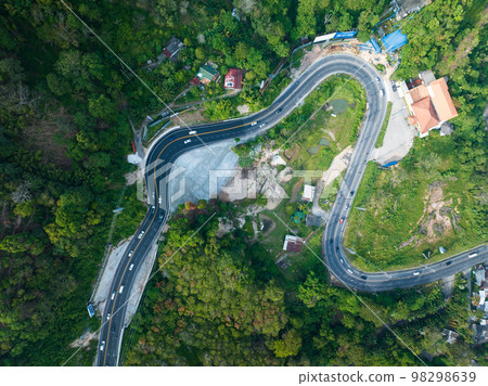 Aerial view top down drone shot above the winding mountain road between the trees rainforest,Phuket Thailand,in summer season weather, Car driving through the curve road Aerial view top down drone shot above the winding mountain road between the trees rainforest,Phuket Thailand,in summer season weather, Car driving through the curve road 98298639