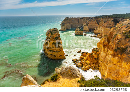 Natural caves and beach, Algarve Portugal. Rock cliff arches of Seven Hanging Valleys and turquoise sea water on coast of Portugal in Algarve region Natural caves and beach, Algarve Portugal. Rock cliff arches of Seven Hanging Valleys and turquoise sea water on coast of Portugal in Algarve region 98298768
