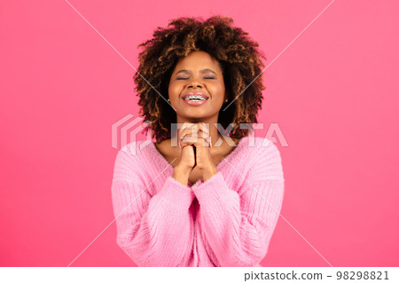 Happy millennial african american curly lady student in casual with closed eyes crossed arms, made wish 98298821