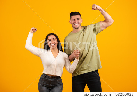 Smiling millennial arabic husband and wife holding hands, show biceps on hand 98299025