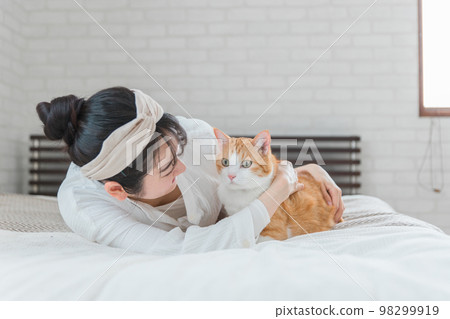 亞洲女人在臥室裡玩貓/寵物 98299919