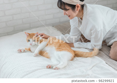 Owner's Asian woman playing with cats and pets in the bedroom (behind the neck, pajamas) Owner's Asian woman playing with cats and pets in the bedroom (behind the neck, pajamas) 98299921