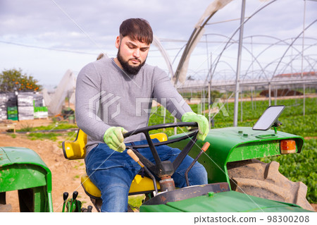 Guy driving farm tractor 98300208