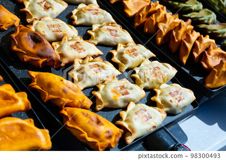 Colorful empanadas in pastry shop 98300493