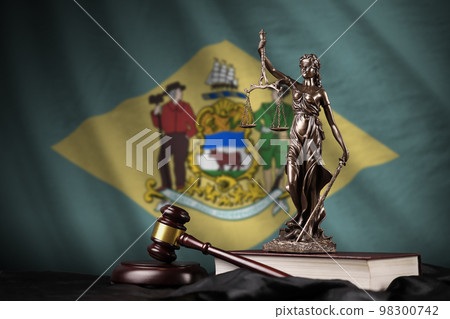 Delaware US state flag with statue of lady justice, constitution and judge hammer on black drapery. Concept of judgement and guilt 98300742