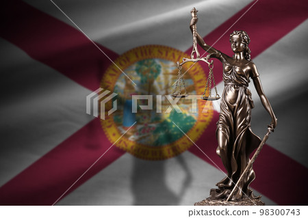 Florida US state flag with statue of lady justice and judicial scales in dark room. Concept of judgement and punishment 98300743