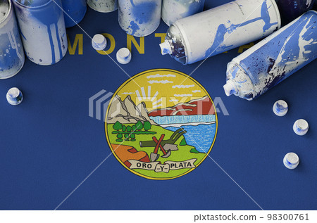 Montana US state flag and few used aerosol spray cans for graffiti painting. Street art culture concept Montana US state flag and few used aerosol spray cans for graffiti painting. Street art culture concept 98300761