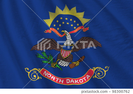 North Dakota US state flag with big folds waving close up under the studio light indoors. The official symbols and colors in banner North Dakota US state flag with big folds waving close up under the studio light indoors. The official symbols and colors in banner 98300762