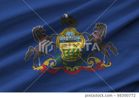 Pennsylvania US state flag with big folds waving close up under the studio light indoors. The official symbols and colors in banner 98300772