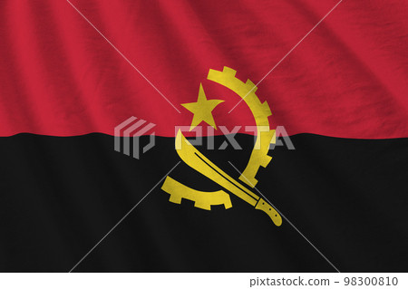 Angola flag with big folds waving close up under the studio light indoors. The official symbols and colors in banner Angola flag with big folds waving close up under the studio light indoors. The official symbols and colors in banner 98300810