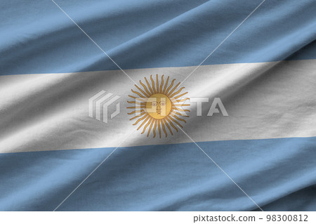 Argentina flag with big folds waving close up under the studio light indoors. The official symbols and colors in banner 98300812