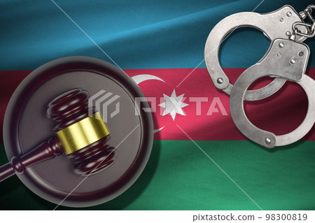 Azerbaijan flag with judge mallet and handcuffs in dark room. Concept of criminal and punishment, background for judgement topics 98300819