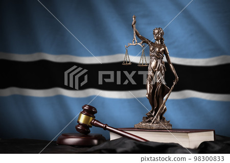 Botswana flag with statue of lady justice, constitution and judge hammer on black drapery. Concept of judgement and guilt 98300833