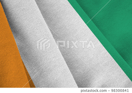 Ivory Coast flag with big folds waving close up under the studio light indoors. The official symbols and colors in banner 98300841