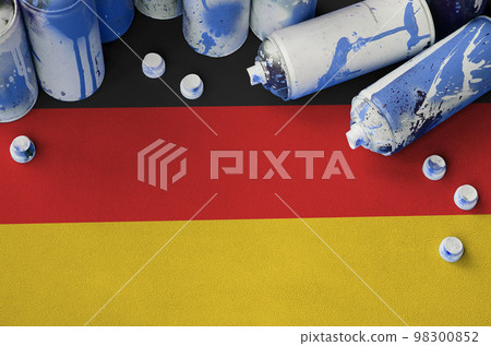 Germany flag and few used aerosol spray cans for graffiti painting. Street art culture concept 98300852
