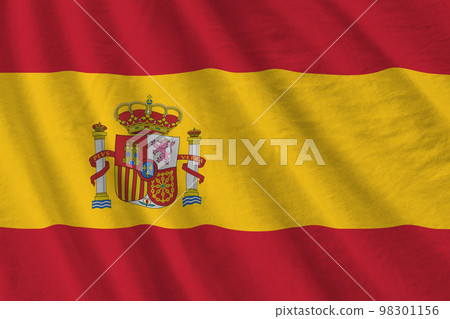 Spain flag with big folds waving close up under the studio light indoors. The official symbols and colors in banner 98301156