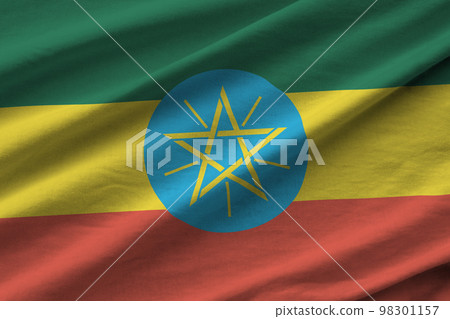 Ethiopia flag with big folds waving close up under the studio light indoors. The official symbols and colors in banner Ethiopia flag with big folds waving close up under the studio light indoors. The official symbols and colors in banner 98301157