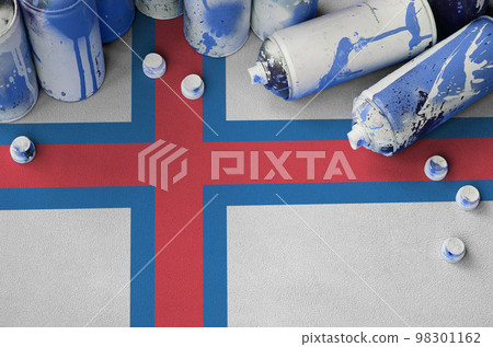 Faroe islands flag and few used aerosol spray cans for graffiti painting. Street art culture concept Faroe islands flag and few used aerosol spray cans for graffiti painting. Street art culture concept 98301162
