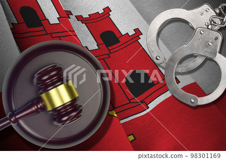 Giblartar flag with judge mallet and handcuffs in dark room. Concept of criminal and punishment, background for judgement topics 98301169