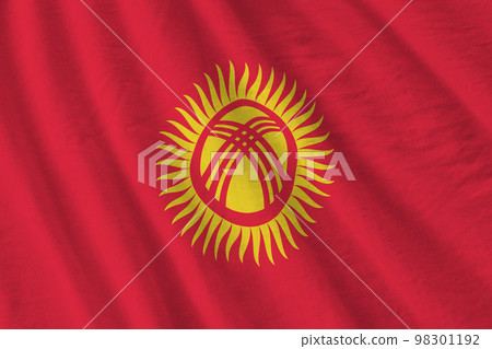 Kyrgyzstan flag with big folds waving close up under the studio light indoors. The official symbols and colors in banner Kyrgyzstan flag with big folds waving close up under the studio light indoors. The official symbols and colors in banner 98301192