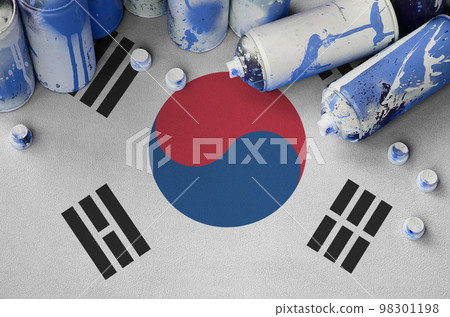 South Korea flag and few used aerosol spray cans for graffiti painting. Street art culture concept South Korea flag and few used aerosol spray cans for graffiti painting. Street art culture concept 98301198