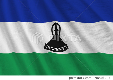 Lesotho flag with big folds waving close up under the studio light indoors. The official symbols and colors in banner Lesotho flag with big folds waving close up under the studio light indoors. The official symbols and colors in banner 98301207