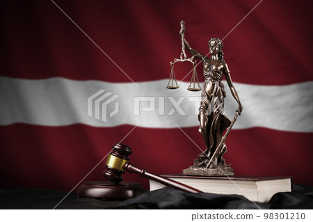 Latvia flag with statue of lady justice, constitution and judge hammer on black drapery. Concept of judgement and guilt Latvia flag with statue of lady justice, constitution and judge hammer on black drapery. Concept of judgement and guilt 98301210