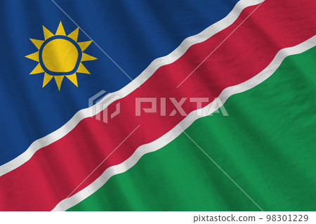Namibia flag with big folds waving close up under the studio light indoors. The official symbols and colors in banner Namibia flag with big folds waving close up under the studio light indoors. The official symbols and colors in banner 98301229