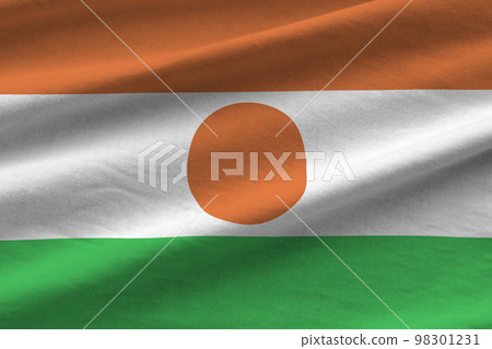 Niger flag with big folds waving close up under the studio light indoors. The official symbols and colors in banner 98301231