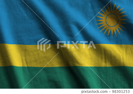 Rwanda flag with big folds waving close up under the studio light indoors. The official symbols and colors in banner Rwanda flag with big folds waving close up under the studio light indoors. The official symbols and colors in banner 98301253