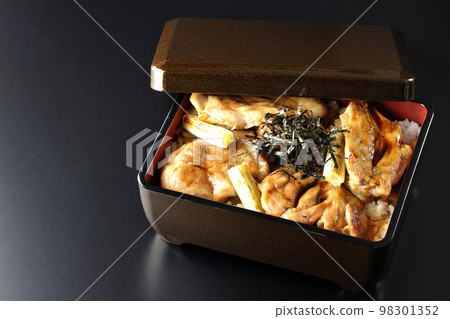 烤長蔥和帶有大量醬汁的烤雞肉串的黑色背景 烤長蔥和帶有大量醬汁的烤雞肉串的黑色背景 98301352