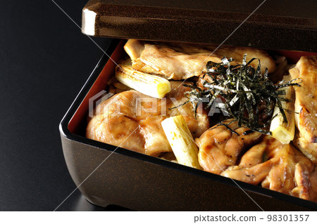 A black background of grilled long green onion and yakitori-ju with plenty of sauce 98301357