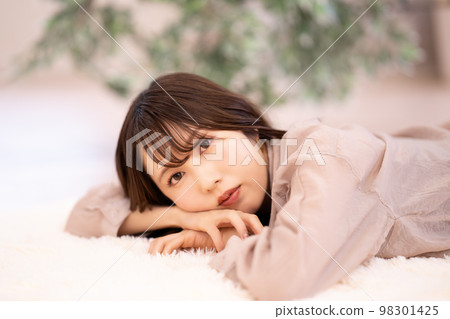 年輕女子躺在地毯上放鬆 98301425