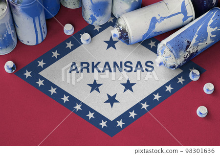 Arkansas US state flag and few used aerosol spray cans for graffiti painting. Street art culture concept 98301636