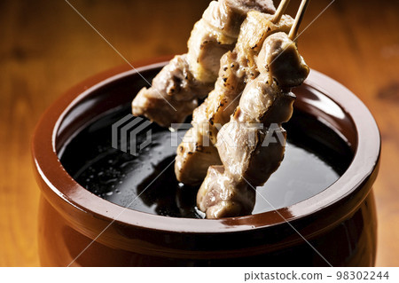 Grilled chicken thigh skewers marinated in yakitori sauce in sauce jar Grilled chicken thigh skewers marinated in yakitori sauce in sauce jar 98302244