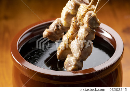 Grilled chicken thigh skewers marinated in yakitori sauce in sauce jar Grilled chicken thigh skewers marinated in yakitori sauce in sauce jar 98302245
