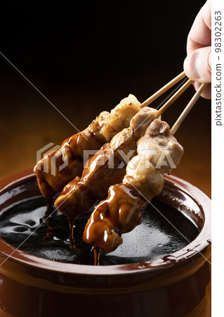 Grilled chicken thigh skewers marinated in yakitori sauce in sauce jar 98302263