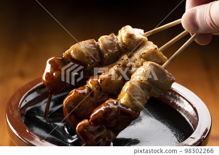 Grilled chicken thigh skewers marinated in yakitori sauce in sauce jar Grilled chicken thigh skewers marinated in yakitori sauce in sauce jar 98302266