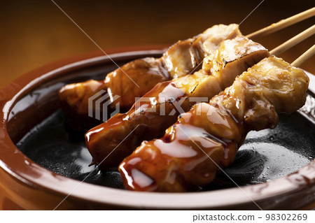 Grilled chicken thigh skewers marinated in yakitori sauce in sauce jar 98302269