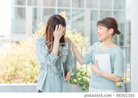 A business woman who is stressed and consults her seniors and bosses about her worries and a woman who comforts her (retirement) A business woman who is stressed and consults her seniors and bosses about her worries and a woman who comforts her (retirement) 98302385