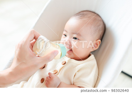 3 個月大的嬰兒盯著媽媽喝牛奶 98302640