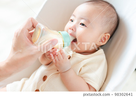 baby cooing while drinking milk baby cooing while drinking milk 98302641