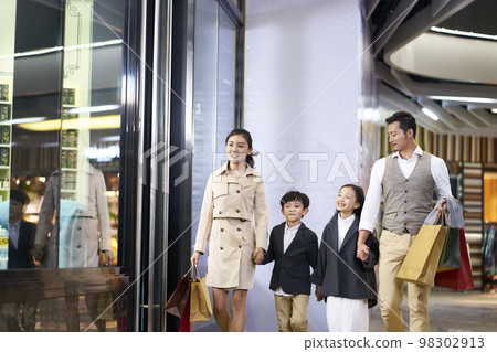 happy asian family with two children walking in shopping mall 98302913