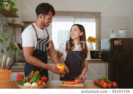 Portrait of young asian couple making salad together at home. cooking food and Lifestyle moment and healthy 98303789