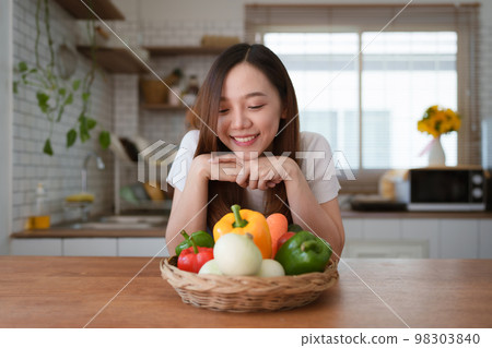 Portrait of beautiful young asian woman making salad at home. cooking food and Lifestyle moment Portrait of beautiful young asian woman making salad at home. cooking food and Lifestyle moment 98303840