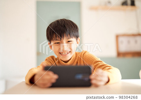 小學生微笑著看著他的智能手機 生活方式圖片 小學生微笑著看著他的智能手機 生活方式圖片 98304268