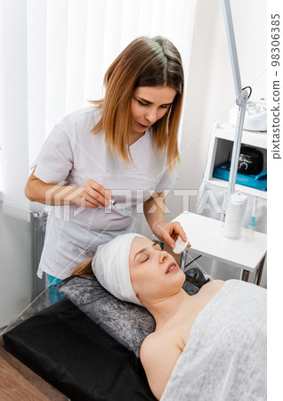 Woman receiving hyaluronic acid injection. Beauty procedure. 98306385