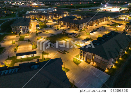 Aerial view from drone of mansions or hotel with beautiful buildings, view of the night city with residential houses and parking. 98306868