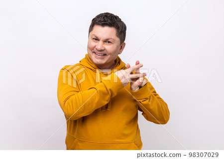 Viral internet topic. Cheerful man smiling joyfully and showing hashtag gesture, hash symbol of message in social media, wearing urban style hoodie. Indoor studio shot isolated on white background. 98307029