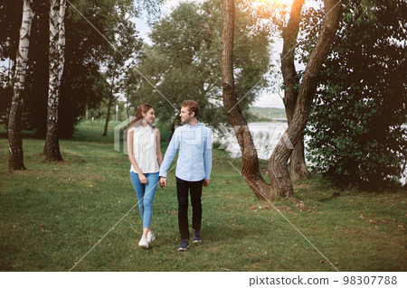 couple in love standing walking along the shore of the lake. 98307788